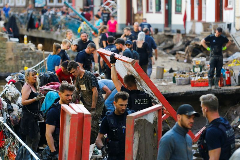 © Reuters. Police officers and volunteers clean rubble in an area affected by floods caused by heavy rainfalls in Bad Muenstereifel, Germany, July 18, 2021. REUTERS/Thilo Schmuelgen