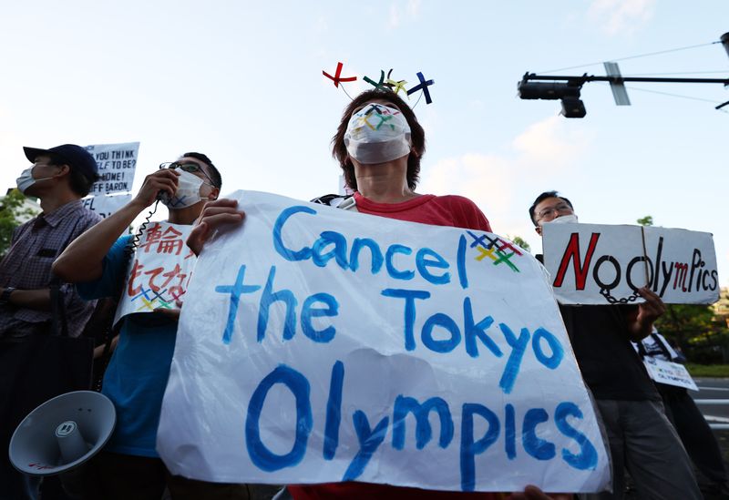 &copy; Reuters. أشخاص يحتجون على دورة الألعاب الأولمبية في طوكيو يوم الأحد. تصوير: كيم كيونج هوون - رويترز