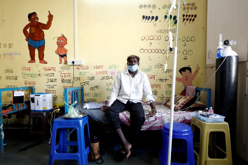 &copy; Reuters. FILE PHOTO: A man suffering from coronavirus disease (COVID-19) receives oxygen support as he sits inside the classroom of a school turned into a COVID-19 care facility on the outskirts of Mumbai, India, May 24, 2021. REUTERS/Francis Mascarenhas