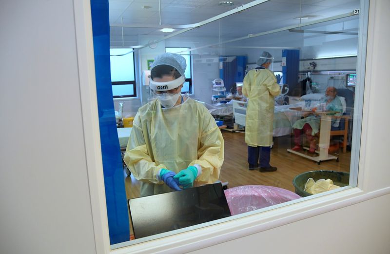 © Reuters. FILE PHOTO: A member of staff takes off PPE in the HDU (High Dependency Unit) at Milton Keynes University Hospital, amid the spread of the coronavirus disease (COVID-19) pandemic, Milton Keynes, Britain, January 20, 2021. REUTERS/Toby Melville