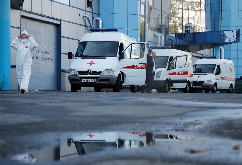 &copy; Reuters. A medical specialist wearing protective gear walks next to ambulances parked outside a temporary hospital for patients infected with the coronavirus disease (COVID-19) at the Lenexpo Exhibition Complex in Saint Petersburg, Russia June 24, 2021. REUTERS/An