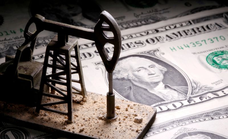 &copy; Reuters. Una miniatura di una pompa petrolifera sopra a una banconota da un dollaro statunitense. REUTERS/Dado Ruvic