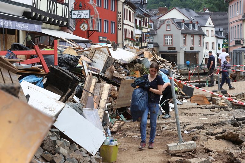 &copy; Reuters. A woman carries a bag in an area affected by floods caused by heavy rainfalls in Bad Muenstereifel, Germany, July 19, 2021. REUTERS/Wolfgang Rattay
