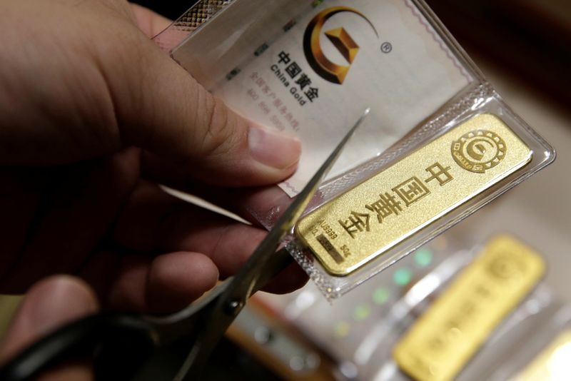 &copy; Reuters. FILE PHOTO:  A man cuts open the bag after he bought 50 gram gold bars as an investment in Beijing, China, August 5, 2019. Picture taken August 5, 2019. REUTERS/Jason Lee/File photo
