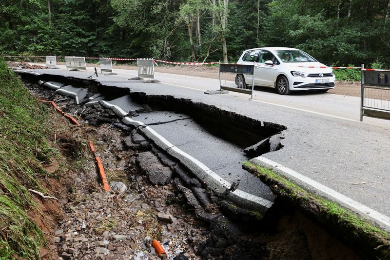 &copy; Reuters. سيارة تعبر طريقا تضرر بشكل بالغ جراء الفيضانات في ألمانيا يوم 19 يوليو تموز 2021. رويترز