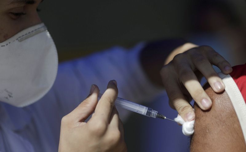 &copy; Reuters. Profissional de saúde aplica vacina da AstraZeneca contra Covid-19 em Duque de Caxias
21/04/2021  REUTERS/Ricardo Moraes
