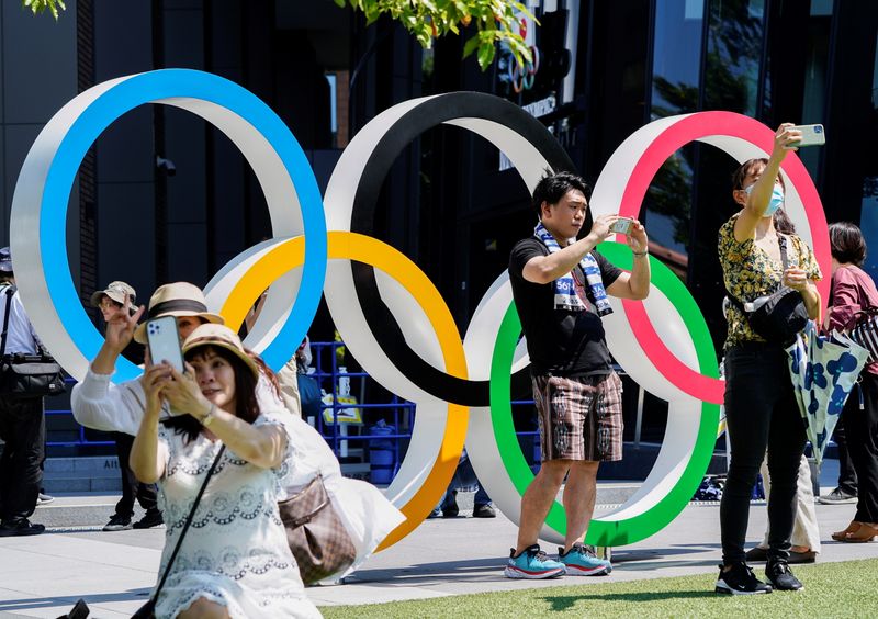 &copy; Reuters. Pessoas tiram selfies em frente aos anéis olímpicos perto do Estádio Nacional em Tóquio
19/07/2021
REUTERS/Naoki Ogura