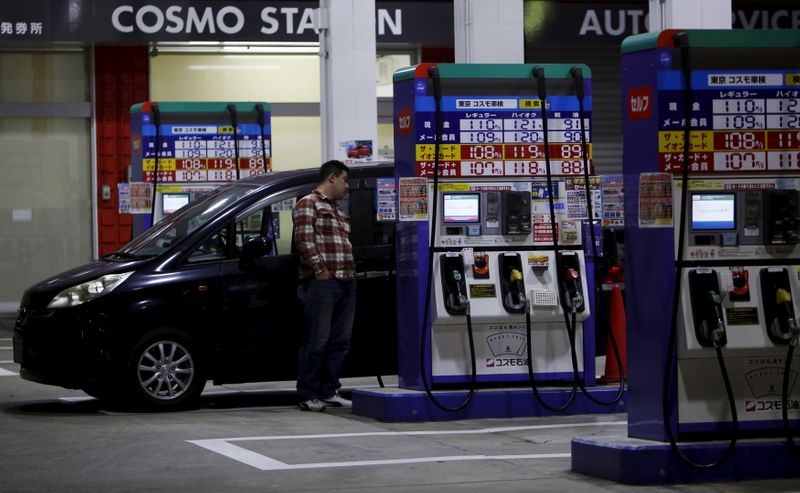 &copy; Reuters. FOTO DE ARCHIVO: Un hombre espera mientras reposta el depósito de su automóvil en una gasolinera de Tokio, Japón, el 16 de diciembre de 2015. REUTERS/Yuya Shino