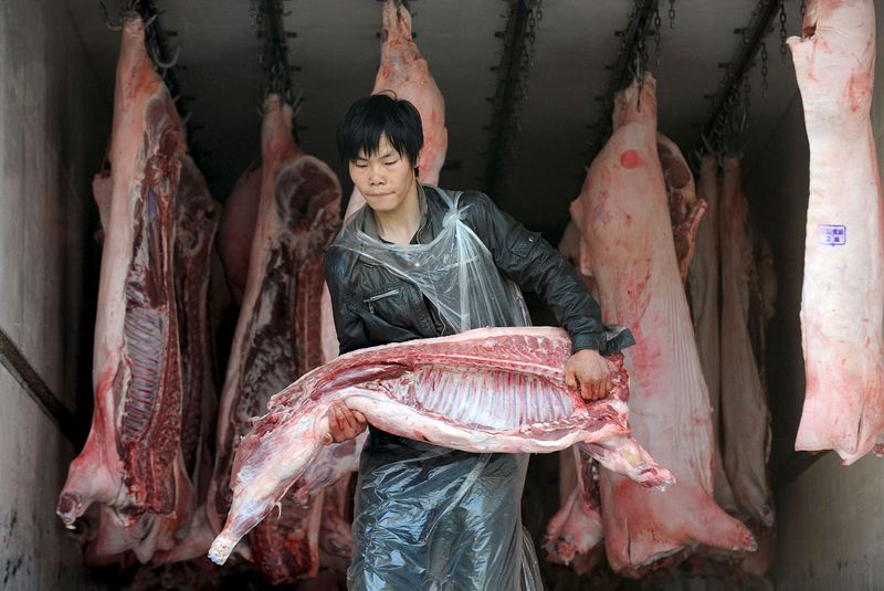 &copy; Reuters. FOTO DE ARCHIVO: Un hombre transporta un canal de cerdo en un mercado al pormallor de Hefei, provincia de Anhui, China, el 28 de abril de 2009. REUTERS/Jianan Yu