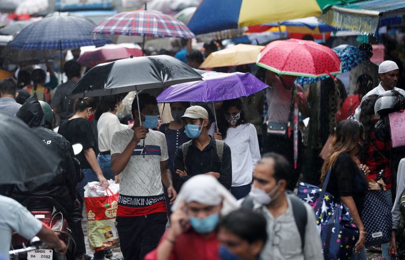 &copy; Reuters. Diverse persone armate di ombrello in un affollato mercato di Mumbai. REUTERS/Francis Mascarenhas