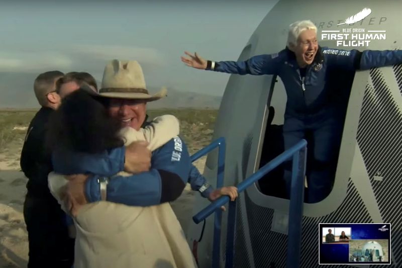 © Reuters. Billionaire businessman Jeff Bezos and pioneering female aviator Wally Funk emerge from their capsule after their flight aboard Blue Origin's New Shepard rocket on the world's first unpiloted suborbital flight near Van Horn, Texas, U.S., July 20, 2021 in a still image from video.  Blue Origin/Handout via REUTERS. 