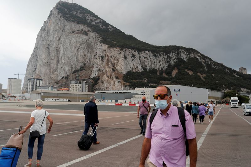 &copy; Reuters. FILE PHOTO: People cross the tarmac of the airport in front of the Rock of Gibraltar in the British overseas territory of Gibraltar, June 24, 2021. REUTERS/Jon Nazca