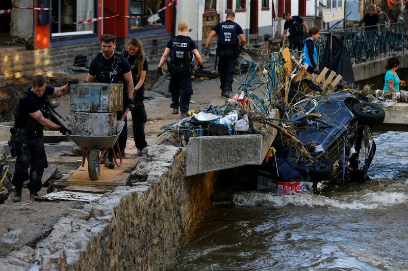 &copy; Reuters. FILE PHOTO: Police officers and volunteers clean rubble in an area affected by floods caused by heavy rainfalls in Bad Muenstereifel, Germany, July 18, 2021. REUTERS/Thilo Schmuelgen