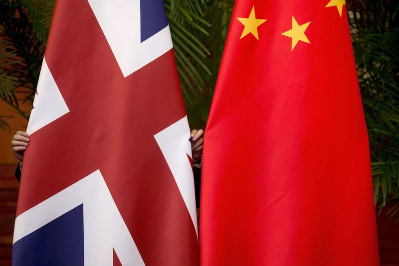 &copy; Reuters. FILE PHOTO: A worker adjusts British and China (R) national flags on display for a signing ceremony at the seventh UK-China Economic and Financial Dialogue "Roundtable on Public-Private Partnerships" at Diaoyutai State Guesthouse in Beijing, China Septemb