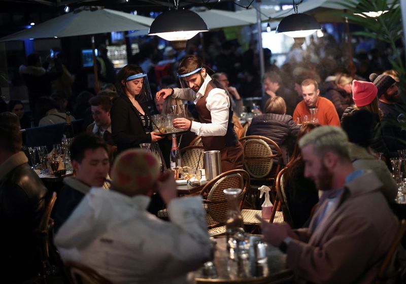 &copy; Reuters. FILE PHOTO: People sit at the terrace of a bar, as the coronavirus disease (COVID-19) restrictions ease, in Soho, London, Britain, April 17, 2021. REUTERS/Henry Nicholls