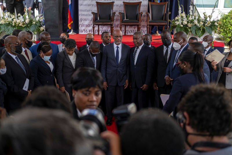 © Reuters. رئيس وزراء هايتي الجديد أريال هنري (في الوسط) يلتقط صورا مع أعضاء حكومته عقب مراسم تعيينه في بورت أو برنس بهايتي يوم الثلاثاء. تصوير: رويترز.