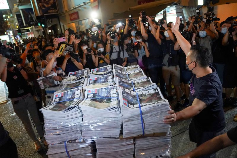 &copy; Reuters. FOTO DE ARCHIVO: Un hombre gesticula mientras lleva ejemplares de la última edición del Apple Daily, publicado por Next Digital, a un quiosco de prensa en Hong Kong, China el 24 de junio de 2021. REUTERS/Lam Yik