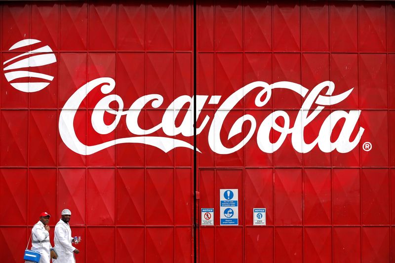 &copy; Reuters. Due perosne passano di fronte ad un logo della Coca Cola, di fronte alla fabbrica di Nairobi, in Kenya. 7 giugno 2018  REUTERS/Baz Ratner/File Photo