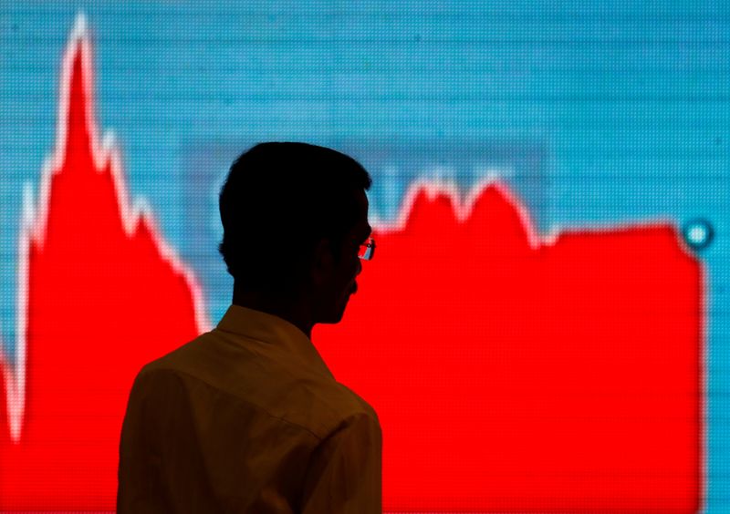 &copy; Reuters. A man walks past a screen displaying news of markets update inside the Bombay Stock Exchange (BSE) building in Mumbai, India, February 6, 2018. REUTERS/Danish Siddiqui