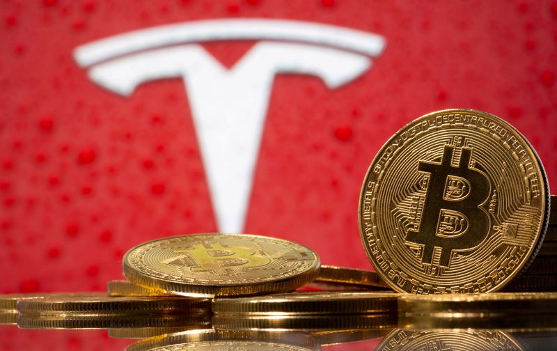 &copy; Reuters. FILE PHOTO: Representations of virtual currency bitcoin are seen in front of Tesla logo in this illustration taken, February 9, 2021. REUTERS/Dado Ruvic