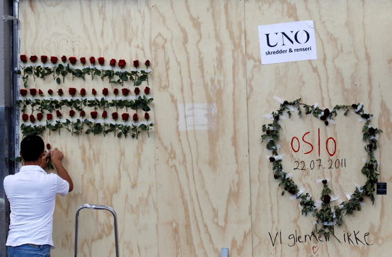 &copy; Reuters. رجل يضع وردة على حائط في ذكرى مرور عشر سنوات على قتل المتطرف المناهض للهجرة أندريس برينج بريفيك 77 شخصا في أوسلو يوم الأربعاء. صورة لرويترز.