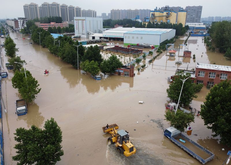 &copy; Reuters. FOTO DE ARCHIVO: Una vista aérea muestra a los trabajadores de rescate evacuando a los residentes en una carretera inundada tras las fuertes lluvias en Zhengzhou, provincia de Henan, China 22 de julio de 2021. Imagen tomada con un dron.  REUTERS/Aly Song