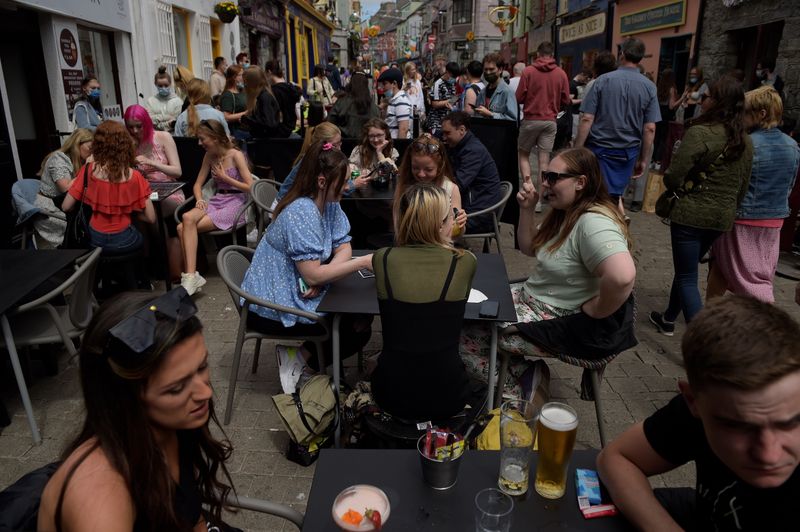 &copy; Reuters. Persone sedute ai tavolini all'aperto di ristoranti e bar nella città di Galway, nell'Irlanda occidentale.  7 giugno 2021. REUTERS/Clodagh Kilcoyne