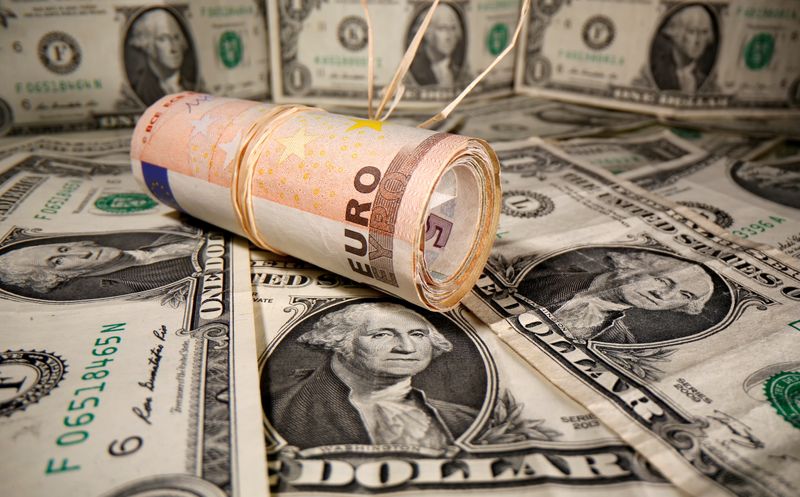 &copy; Reuters. Banconote da 10 euro arrotolate e disposte sopra biglietti da 1 dollaro. 26 maggio 2020. REUTERS/Dado Ruvic/Illustration/File Photo