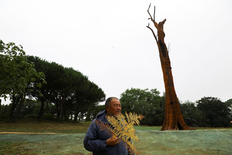 &copy; Reuters. El artista chino Ai Weiwei posa junto a una estructura de hierro que representa a un árbol, en su más reciente instalación en Porto, Portugal. Julio 22, 2021. REUTERS/Violeta Santos Moura