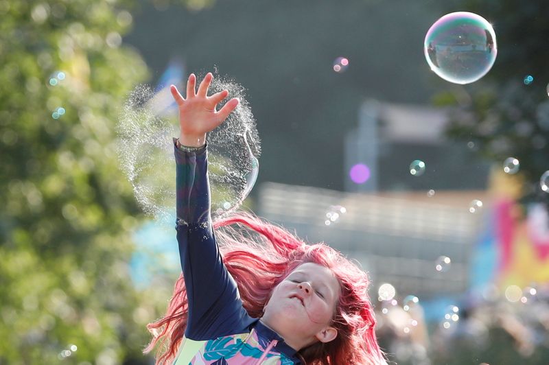 &copy; Reuters. A young festivalgoer jumps to burst a bubble at Latitude Festival at Henham Park, Britain, July 22, 2021.  REUTERS/Peter Cziborra    