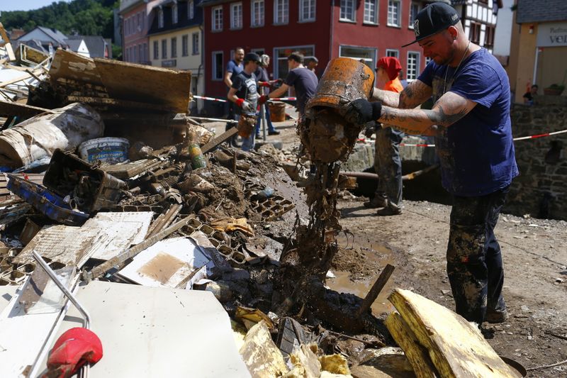 &copy; Reuters. FILE PHOTO: People help to clean up following heavy rainfalls, in Bad Muenstereifel, North Rhine-Westphalia state, Germany, July 21, 2021. REUTERS/Thilo Schmuelgen/File Photo