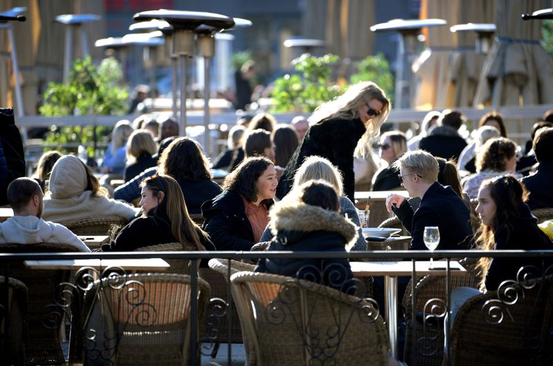 &copy; Reuters. FILE PHOTO: People enjoy the sun at an outdoor restaurant, despite the continuing spread of coronavirus disease (COVID-19), in Stockholm, Sweden March 26, 2020. TT News Agency/Janerik Henriksson via REUTERS /File Photo