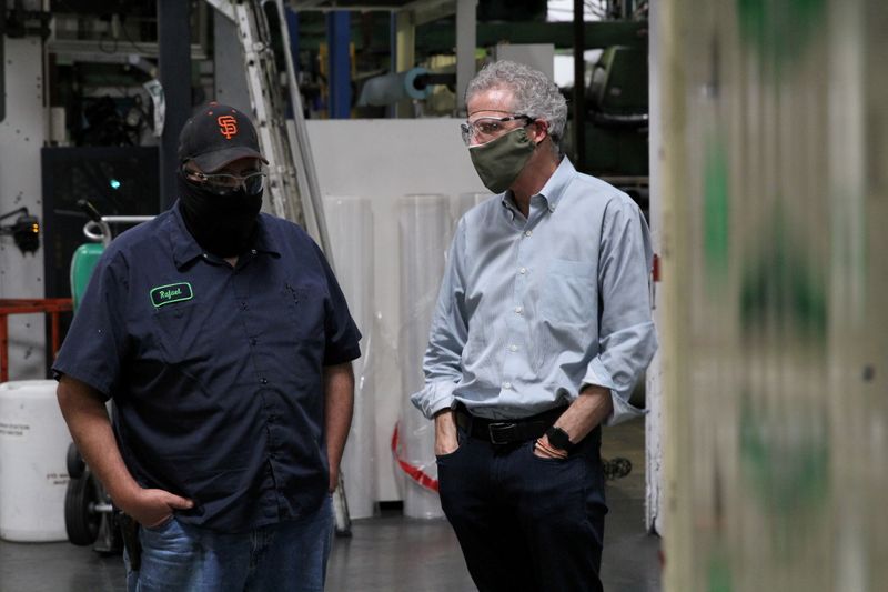 &copy; Reuters. FILE PHOTO: Kevin Kelly, CEO of Emerald Packaging, talks with an employee as they wear protective masks on a production floor of the company, which prints packaging material to be used for produce, amid the coronavirus disease (COVID-19) outbreak, in Unio