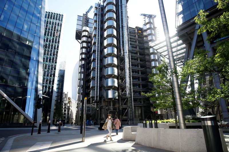 &copy; Reuters. FILE PHOTO: A woman wearing a face mask walks past the Lloyd's of London building following the outbreak of the coronavirus disease (COVID-19), London, Britain, May 6, 2020. REUTERS/Henry Nicholls/File Photo