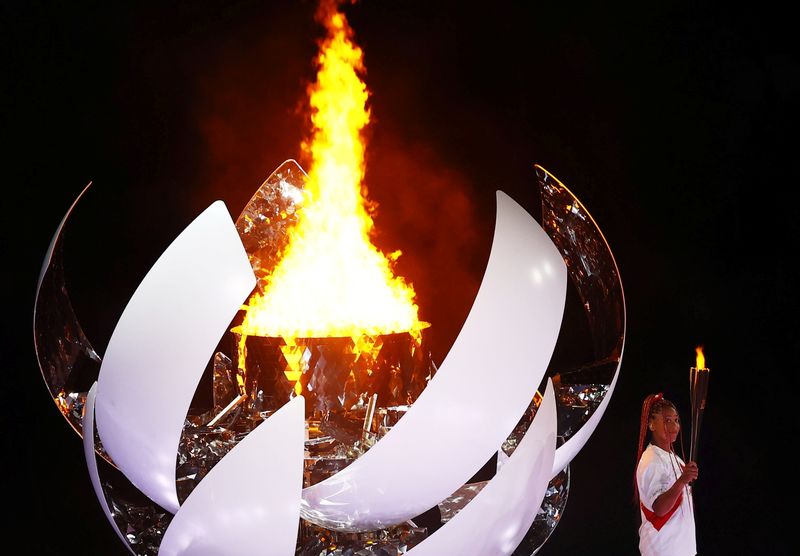 © Reuters. Tokyo 2020 Olympics - The Tokyo 2020 Olympics Opening Ceremony - Olympic Stadium, Tokyo, Japan - July 23, 2021. Naomi Osaka of Japan holds the Olympic torch after lighting the Olympic cauldron at the opening ceremony REUTERS/Mike Blake    