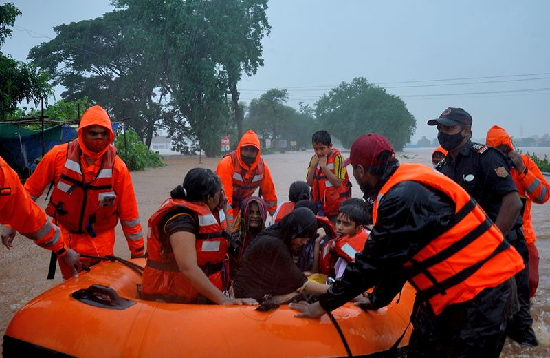 © Reuters. Rescue workers evacuate people from a flooded area to safer places after heavy rains in Kolhapur in the western state of Maharashtra, India, July 23, 2021. REUTERS/Abhijeet Gurjar  