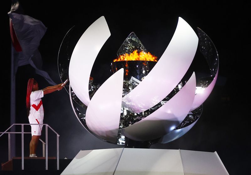 © Reuters. لاعبة التنس اليابانية أوساكا توقد المرجل الأولمبي إيذانا بانطلاق أولمبياد طوكيو يوم الجمعة. تصوير: كاي فافنباخ - رويترزز 