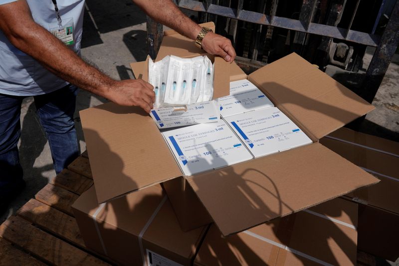&copy; Reuters. Un trabajador del sistema de salud muestra una caja que contiene jeringas donadas por la comunidad cubana en los Estados Unidos, en La Habana, Cuba, el 23 de julio de 2021. REUTERS/Alexandre Meneghini