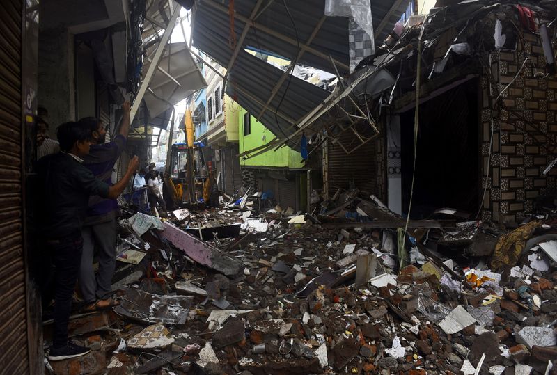 &copy; Reuters. People use their mobile phones to take pictures of a collapsed building following rains in Mumbai, India, July 23, 2021. REUTERS/Stringer.