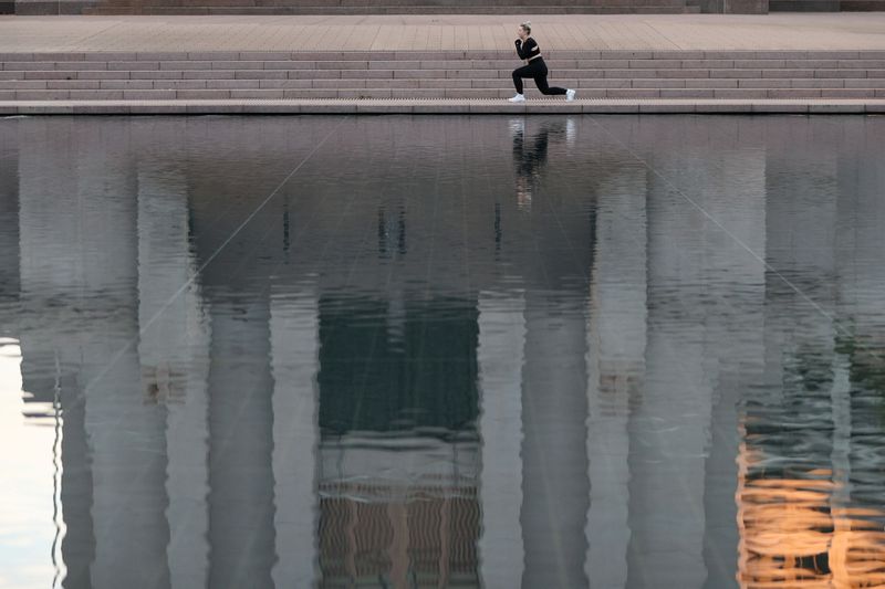 &copy; Reuters. FILE PHOTO: A woman exercises on the empty steps in front of the Anzac Memorial at the Pool of Reflection as gyms are closed during a lockdown to curb the spread of a coronavirus disease (COVID-19) outbreak in Sydney, Australia, July 22, 2021.  REUTERS/Lo