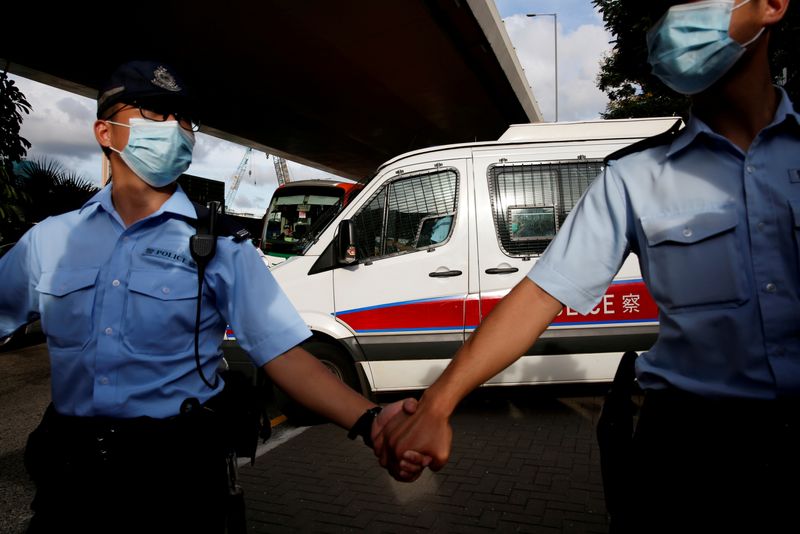 © Reuters. FILE PHOTO: Police officers escort a prison van which is carrying Tong Ying-kit, the first person charged under the new national security law, as he leaves West Kowloon Magistrates' Courts, in Hong Kong, China July 6, 2020. REUTERS/Tyrone Siu/File Photo