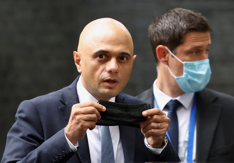 © Reuters. FILE PHOTO: Britain's new Health Secretary Sajid Javid holds a face mask, as he leaves the Downing Street in London, Britain, June 30, 2021. REUTERS/Henry Nicholls