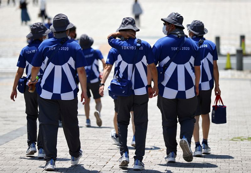 &copy; Reuters. Jul 24, 2021.  
Foto de archivo de un grupo de voluntarios de los Juegos de Tokio caminando por las calles de la capital japonesa.
REUTERS/Issei Kato/
