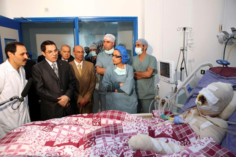 &copy; Reuters. الرئيس التونسي زين العابدين بن علي لدى زيارته لبائع الخضر محمد بوعزيزي الذي أشعل النار في نفسه بعد أن صادرت الشرطة عربته في مستشفى بالقرب من