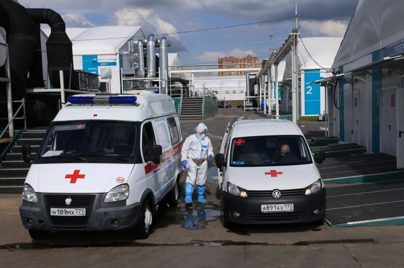 © Reuters. A medical specialist wearing protective gear stands next to ambulances outside a hospital for patients infected with the coronavirus disease (COVID-19) on the outskirts of Moscow, Russia July 2, 2021. REUTERS/Tatyana Makeyeva