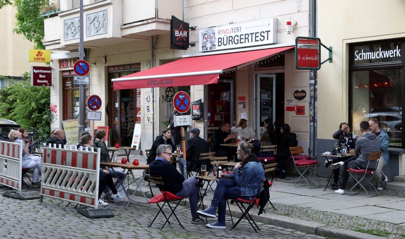 &copy; Reuters. FOTO DE ARCHIVO: Personas disfrutan de sus bebidas en una terraza del bar Revolte, mientras los cafés, bares y restaurantes reabren sus terrazas en Berlín, Alemania, el 21 de mayo de 2021. REUTERS/Christian Mang