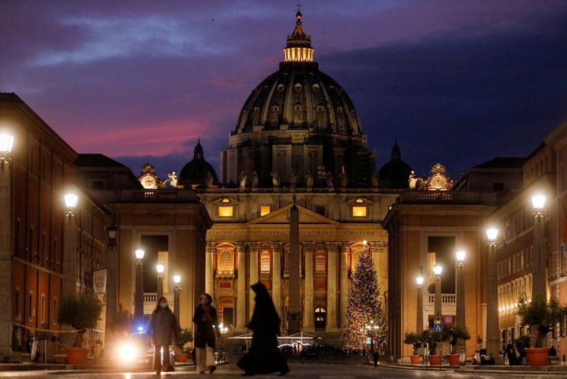 &copy; Reuters. Cupola di San pietro vista al tramonto da Via della Conciliazione, a poche ore dalla messa di Natale celebrata da papa Francesco. Roma, 24 dicembre 2020. REUTERS/Guglielmo Mangiapane/File Photo