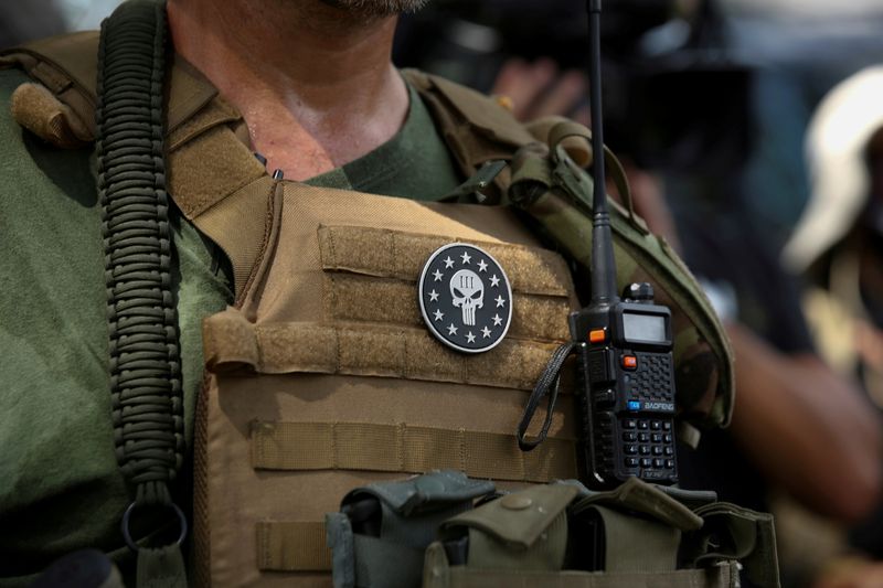 © Reuters. FILE PHOTO: A militia member with body armor and a Three Percenters militia patch stands in Stone Mountain as various militia groups stage rallies at Stone Mountain, Georgia, U.S. August 15, 2020.  REUTERS/Dustin Chambers/File Photo