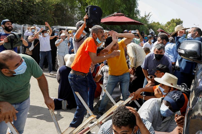 &copy; Reuters. أنصار حزب النهضة يحاولون الهرب من حجارة يلقيها مؤيدو الرئيس قيس عيسى في العاصمة تونس يوم الاثنين. تصوير: زبير السويسي - رويترز.