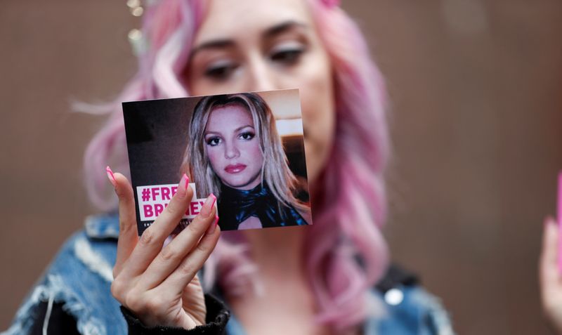 © Reuters. Supporter of pop star Britney Spears Melanie Mandarano holds a postcard on the day of a conservatorship case hearing at Stanley Mosk Courthouse in Los Angeles, California, U.S., July 26, 2021.  REUTERS/Mario Anzuoni